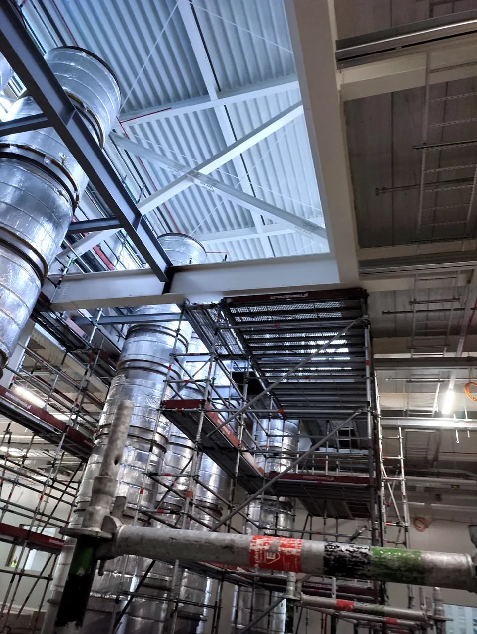 Large diameter ventilation ductwork installed with scaffolding access