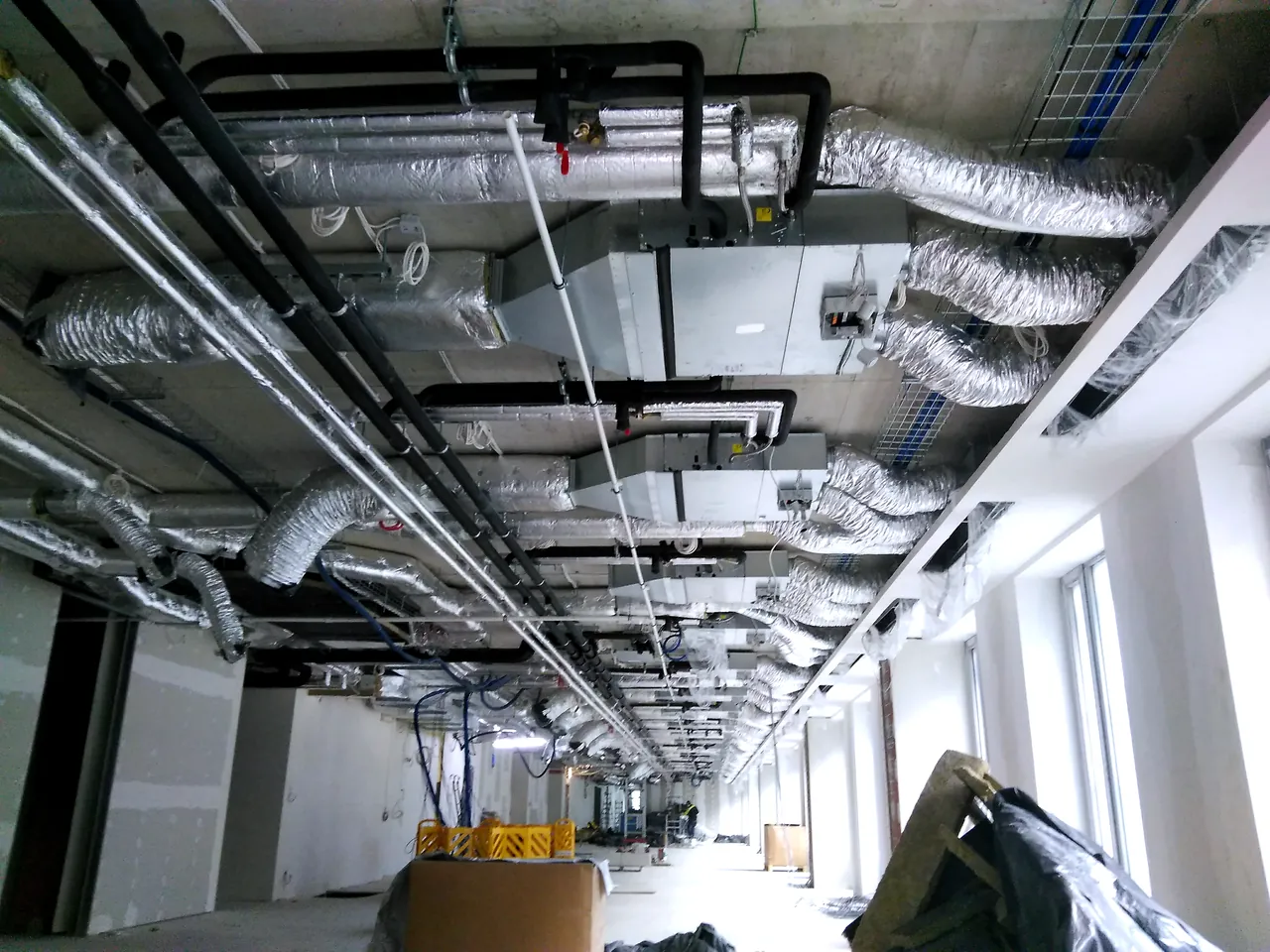 Mechanical installation works in a dense building services corridor