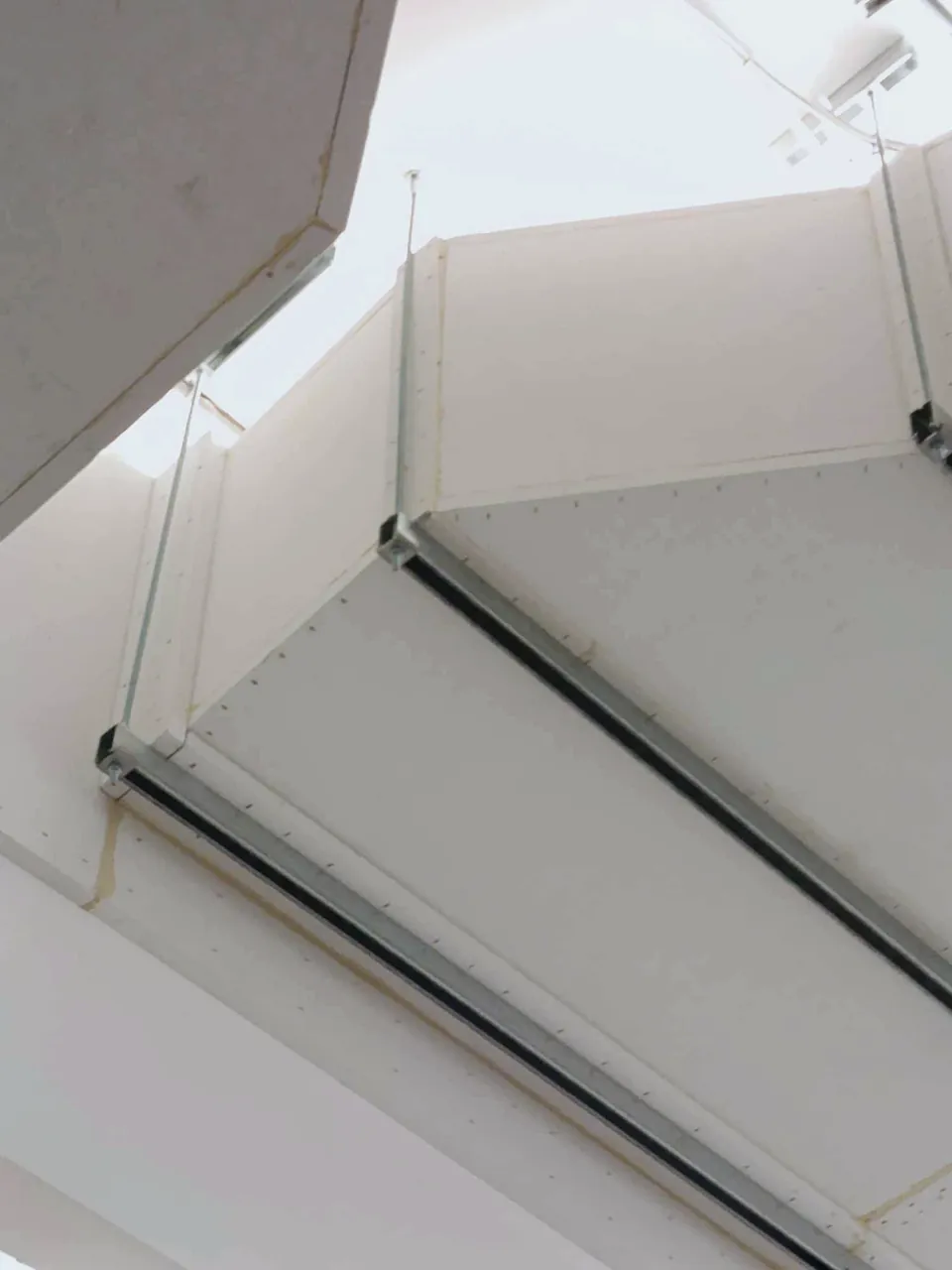 Fire-rated PROMAT board ductwork suspended below a concrete ceiling