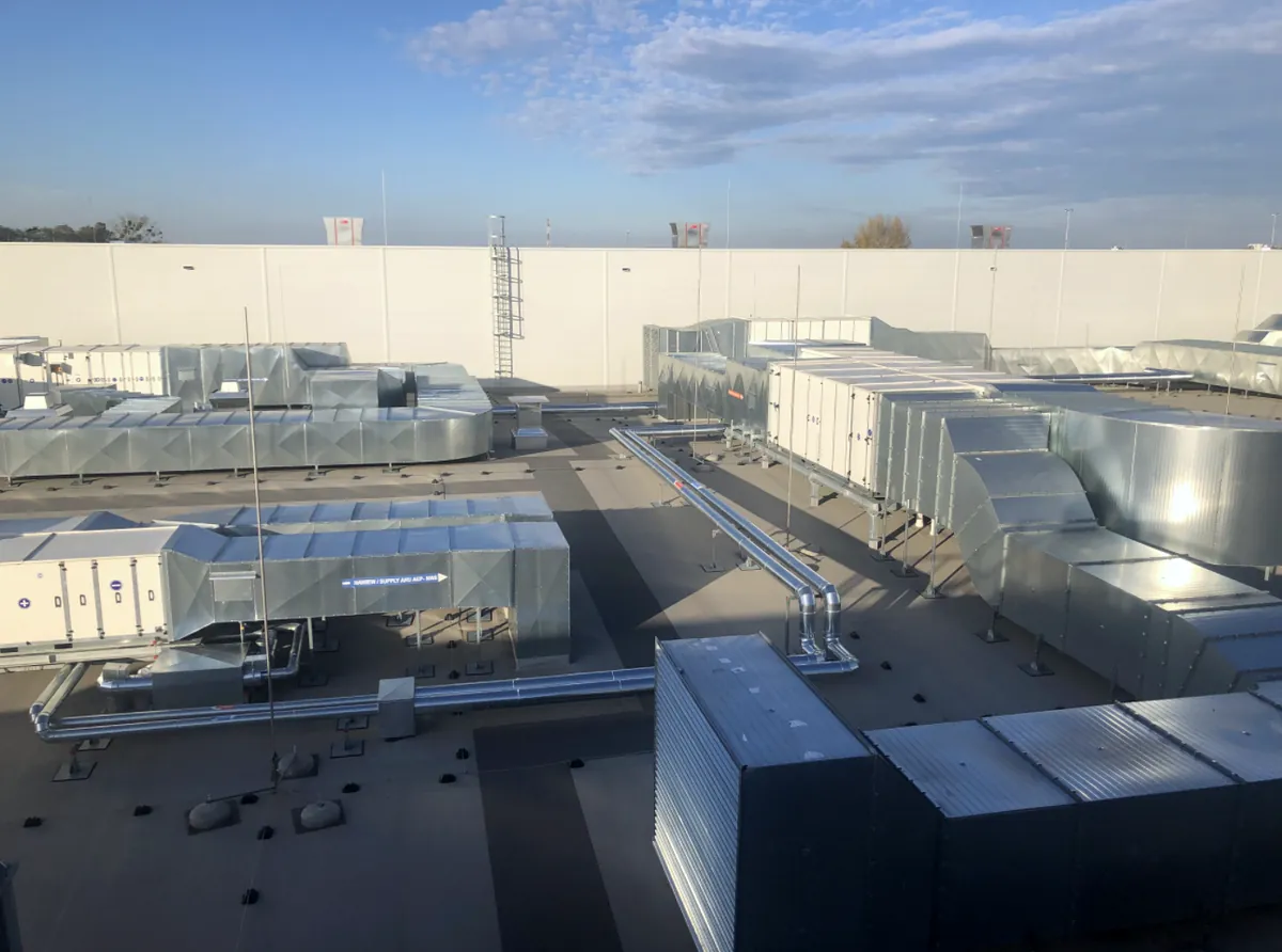 Complete rooftop industrial HVAC installation with air handling units and ductwork